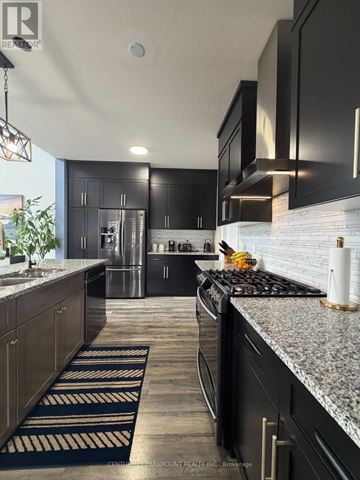 Collingwood apartment for rent - A modern kitchen with black cabinets and a granite countertop.