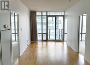 Toronto (Bay Street Corridor) condo for rent - A spacious room with wooden floors and large windows.