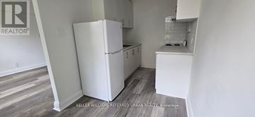 Toronto (Yonge-Eglinton) multi-family for rent - A white refrigerator in a kitchen with wooden floors.