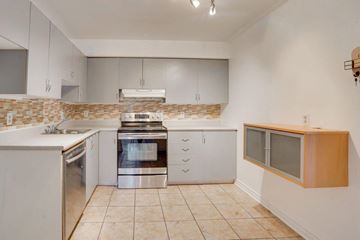 Gatineau (Hull) condo for rent - A kitchen with white cabinets and a tiled backsplash.
