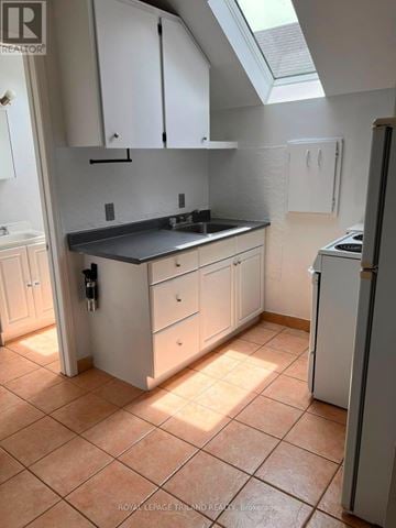 London South (South E) triplex for rent - A kitchen with white cabinets and a black countertop.