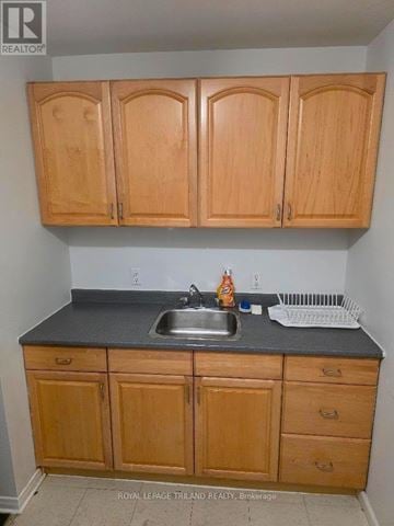 London South (South E) triplex for rent - A kitchen with wooden cabinets and a sink.