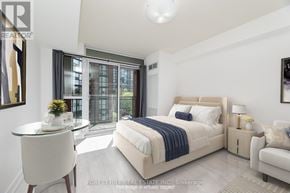 Toronto (Niagara) condo for rent - A bedroom with a large bed and a balcony with a view of a building.