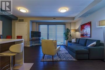 Greater Sudbury apartment for rent - A living room with a yellow chair and a grey couch.
