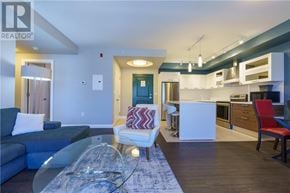 Greater Sudbury apartment for rent - A modern living room with a glass coffee table and a blue couch.