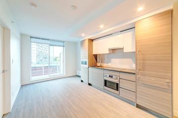 Surrey apartment for rent - A modern kitchen with wooden cabinets and stainless steel appliances.