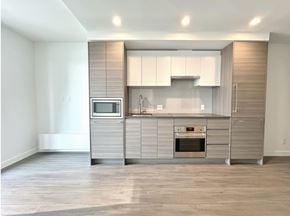 Surrey apartment for rent - A modern kitchen with a microwave, oven, and cabinets.