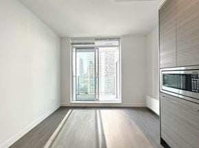 Surrey apartment for rent - A kitchen with a microwave and a window with a view of a building outside.