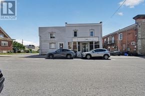 Smiths Falls apartment for rent - Two cars are parked in front of a white building.