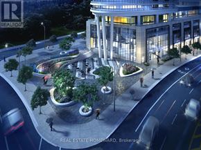 Toronto (North St. James Town) condo for rent - A nighttime view of a city street with a large building and a roundabout with trees.