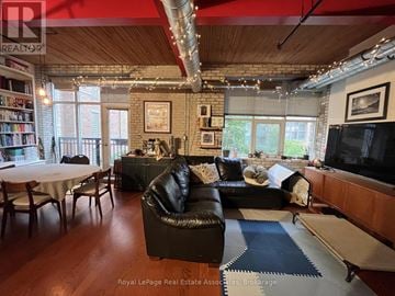Toronto (Niagara) condo for rent - A living room with a black leather couch and a television.