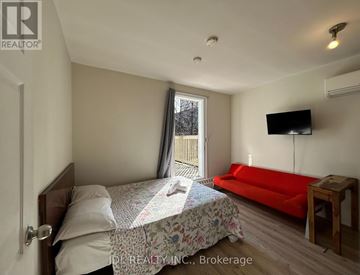 Toronto (Moss Park) apartment for rent - A bedroom with a bed, a couch, and a television.