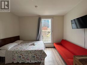 Toronto (Moss Park) apartment for rent - A bedroom with a bed, a sofa, and a television.