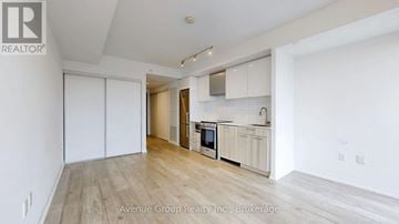 Toronto (Church-Yonge Corridor) condo for rent - A spacious kitchen with white cabinets and a wooden floor.
