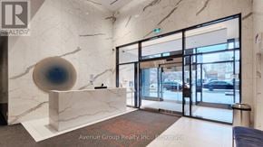 Toronto (Church-Yonge Corridor) condo for rent - A reception area with a marble counter and a large blue and black sculpture.