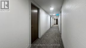 Toronto (Church-Yonge Corridor) condo for rent - A long hallway with a brokerage logo on the wall.