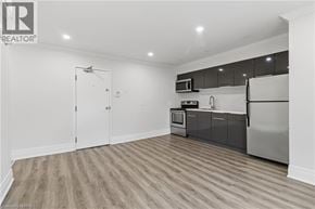 Brantford apartment for rent - A kitchen with a white refrigerator, microwave, and oven.