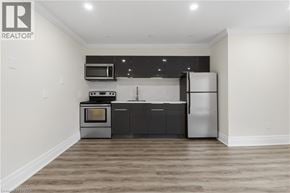 Brantford apartment for rent - A modern kitchen with a refrigerator, oven, microwave, and cabinets.