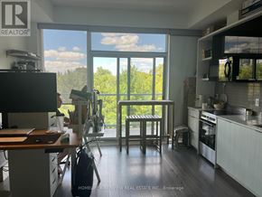 Toronto (Casa Loma) condo for rent - A kitchen with a table and chairs in front of a large window.