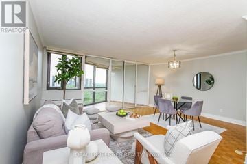 Ottawa condo for rent - A living room with a grey couch, a white couch, a coffee table, and a dining table with chairs.