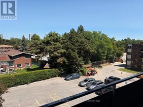 Toronto (Parkwoods-Donalda) condo for rent - A parking lot with cars and a building in the background.