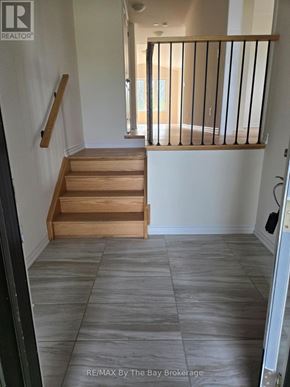 Wasaga Beach apartment for rent - A hallway with a staircase and a balcony.