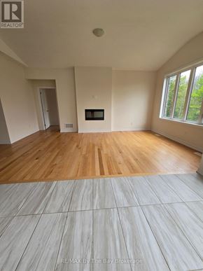 Wasaga Beach apartment for rent - A room with wooden flooring and a fireplace is shown.