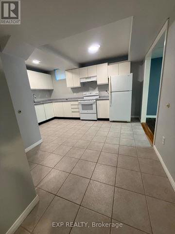 Bradford West Gwillimbury (Bradford) apartment for rent - A kitchen with white appliances and cabinets in a room with tiled flooring.