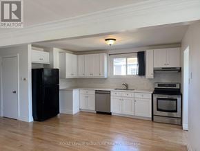 Bradford West Gwillimbury (Bradford) apartment for rent - A kitchen with white cabinets and a black fridge.