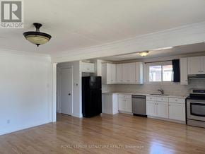 Bradford West Gwillimbury (Bradford) apartment for rent - A kitchen with white cabinets and a black refrigerator.