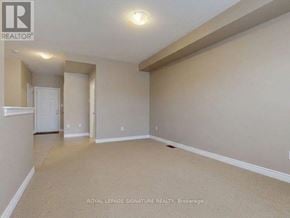 Oakville (Go Glenorchy) townhouse for rent - A spacious room with beige carpeting and white walls, with a doorway leading to another room.