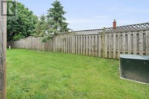 London South (South T) townhouse for rent - A backyard with a wooden fence and a green lawn.