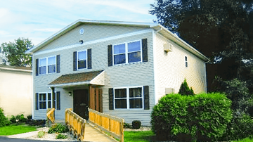 Earlville apartment for rent - A house with a grey siding and a brown door.