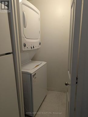 Toronto (Woburn) condo for rent - A white dryer is sitting in a small room.