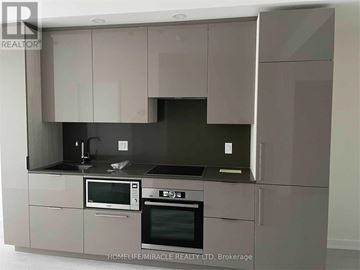 Toronto (Waterfront Communities) condo for rent - A modern kitchen with a microwave, oven, and sink.