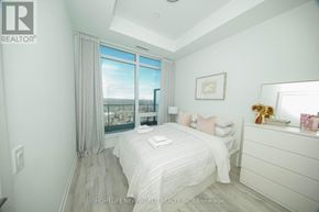 Toronto (Newtonbrook East) condo for rent - A bedroom with a large bed and a view of the city through the window.