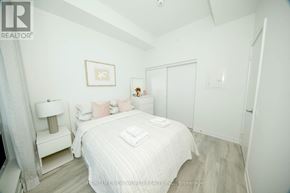 Toronto (Newtonbrook East) condo for rent - A bedroom with a bed, nightstand, and lamp.