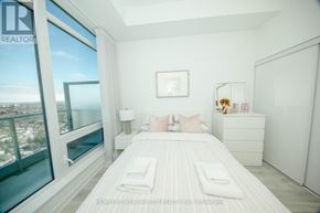 Toronto (Newtonbrook East) condo for rent - A bedroom with a large bed and a view of the city.