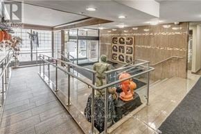 Toronto (Eglinton East) condo for rent - A reception area with a glass barrier and a woman statue.