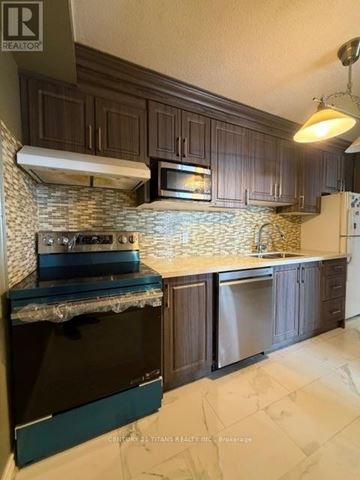 Toronto (Eglinton East) condo for rent - A kitchen with a black stove top oven and a black refrigerator.