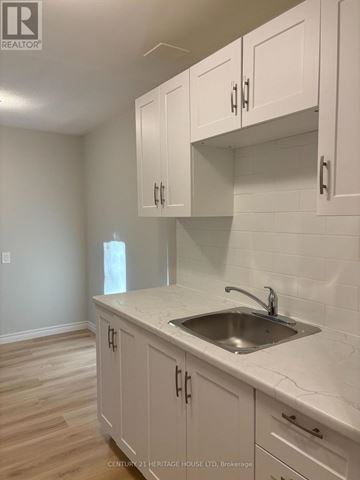 St. Thomas multi-family for rent - A kitchen with white cabinets and a marble countertop.