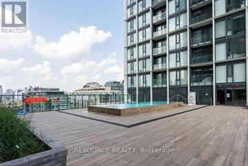Toronto (Moss Park) condo for rent - A modern building with a pool in the courtyard.