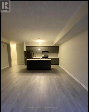 Cambridge townhouse for rent - A spacious room with a kitchenette and a bed.