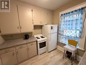 Brantford multi-family for rent - A kitchen with white appliances and cabinets.