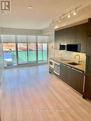 Toronto (Bayview Village) condo for rent - A modern kitchen with wooden floors and a large window overlooking a pool.