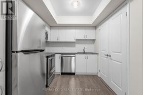 Toronto (Eglinton East) townhouse for rent - A modern kitchen with white cabinets and stainless steel appliances.