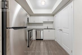 Toronto (Eglinton East) townhouse for rent - A kitchen with white cabinets and a stainless steel refrigerator.