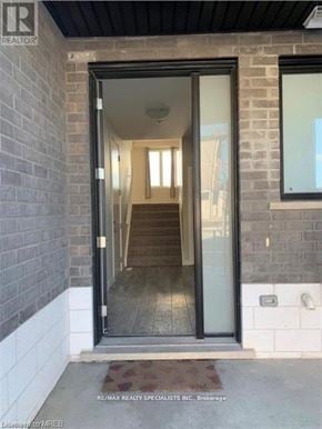 London North (North M) townhouse for rent - A glass door entrance to a building with a brick wall on the left.