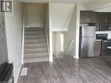 London North (North M) townhouse for rent - A kitchen with a refrigerator, microwave, and oven is shown in a real estate listing.