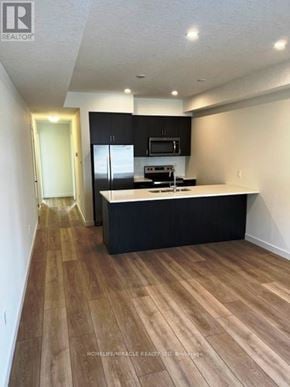 Cambridge townhouse for rent - A kitchen with black cabinets and a wooden floor.